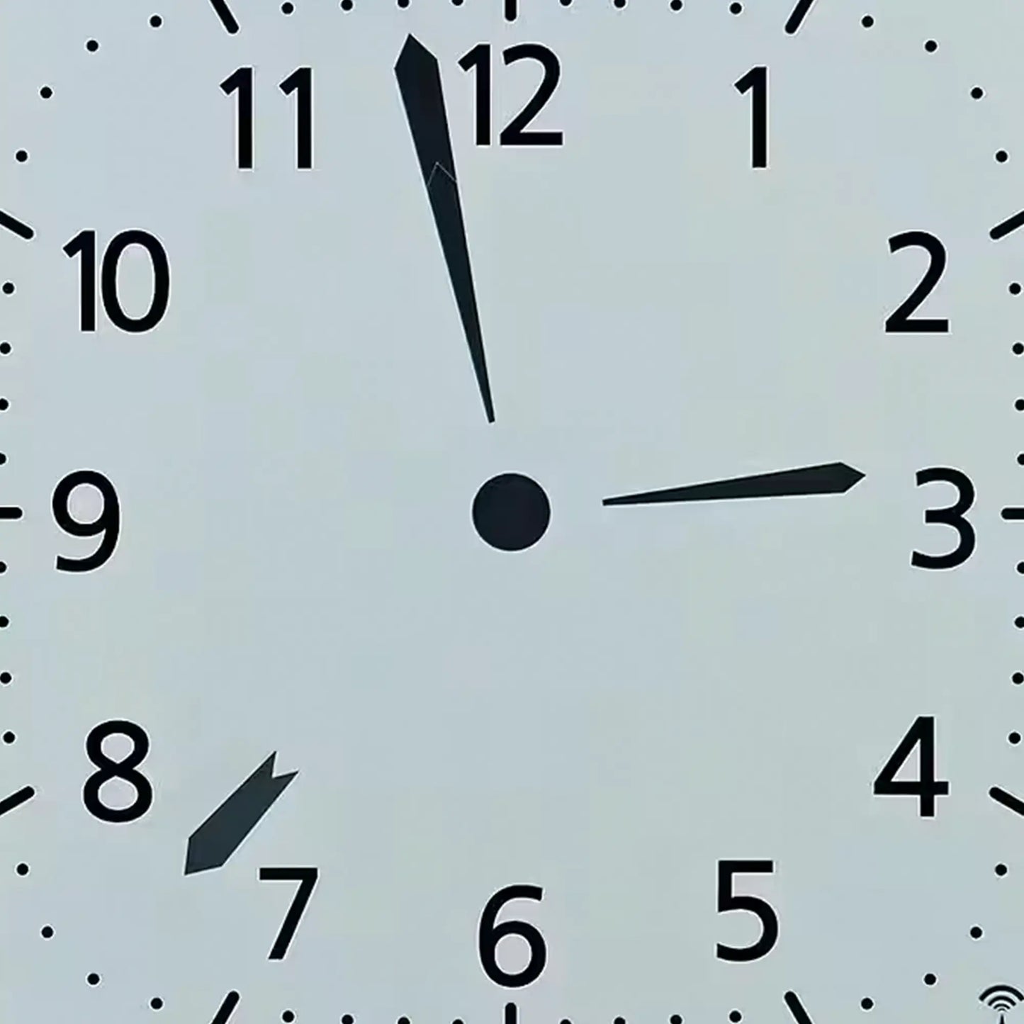 Silberne Funk-Wanduhr: Nahaufnahme des analogen Zifferblatts mit schwarzen Zeigern
