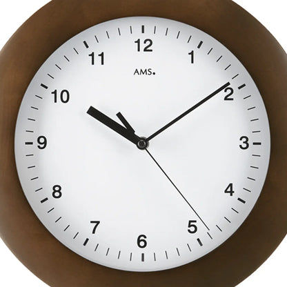 Nahansicht der Wanduhr: nussbaumfarbener Rand, weißes Zifferblatt, schwarze Zeiger und AMS