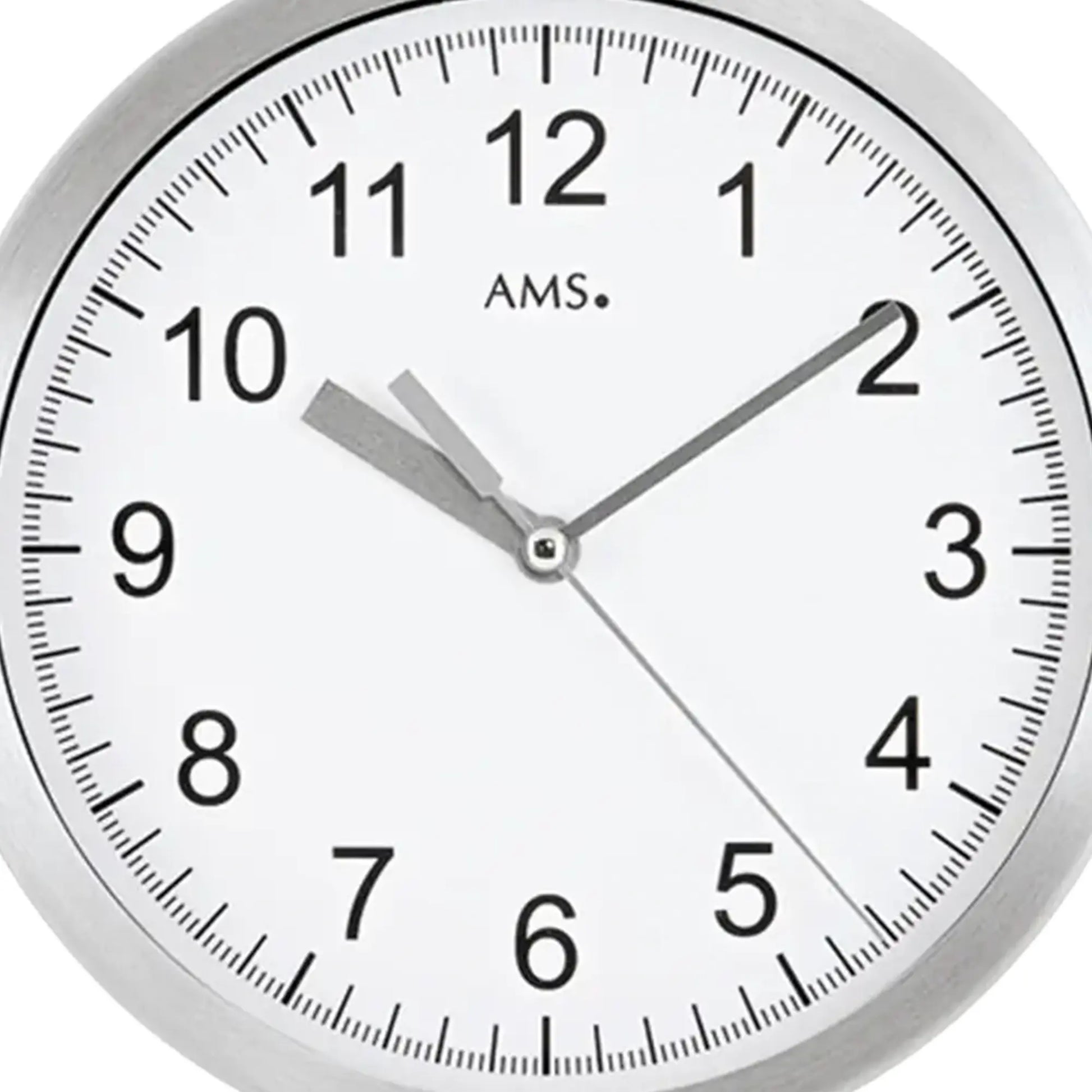 Nahaufnahme Wanduhr: weißes Zifferblatt mit schwarzen Zahlen, Aluminiumrahmen und Zeigern
