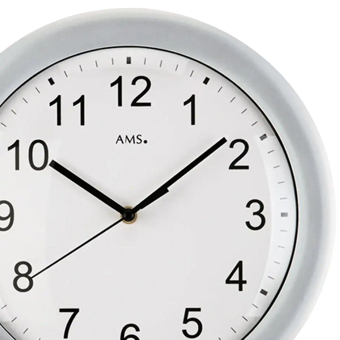 Nahaufnahme der Wanduhr: weißes Zifferblatt, schwarze Zahlen, schwarze Zeiger, silberner Rand