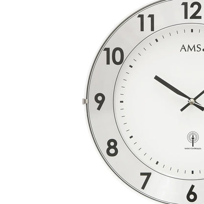 Nahaufnahme Funk-Wanduhr: weißes Ziffernblatt, schwarze Ziffern und Metallring