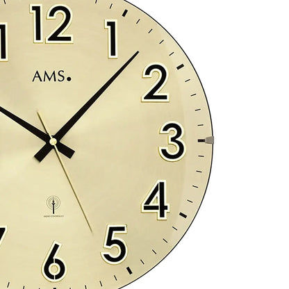 Detailansicht der Wanduhr: goldfarbenes Zifferblatt mit schwarzen Zeigern, Ziffern 2–6