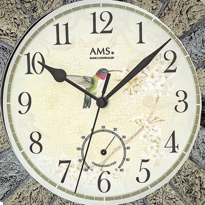 Nahaufnahme Funk-Wanduhr: beiges Ziffernblatt mit AMS, Vogelmotiv und Thermometeranzeige