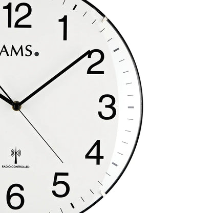 Nahaufnahme der Funk-Wanduhr: weißes Ziffernblatt, schwarze Zeiger, arabische Zahlen