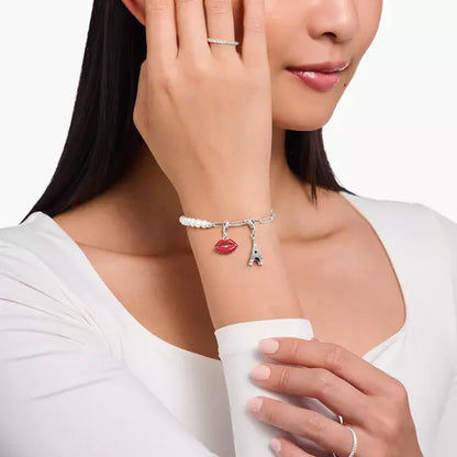 Eifelturm-Charm an feiner silberner Kette, getragen am Hals.