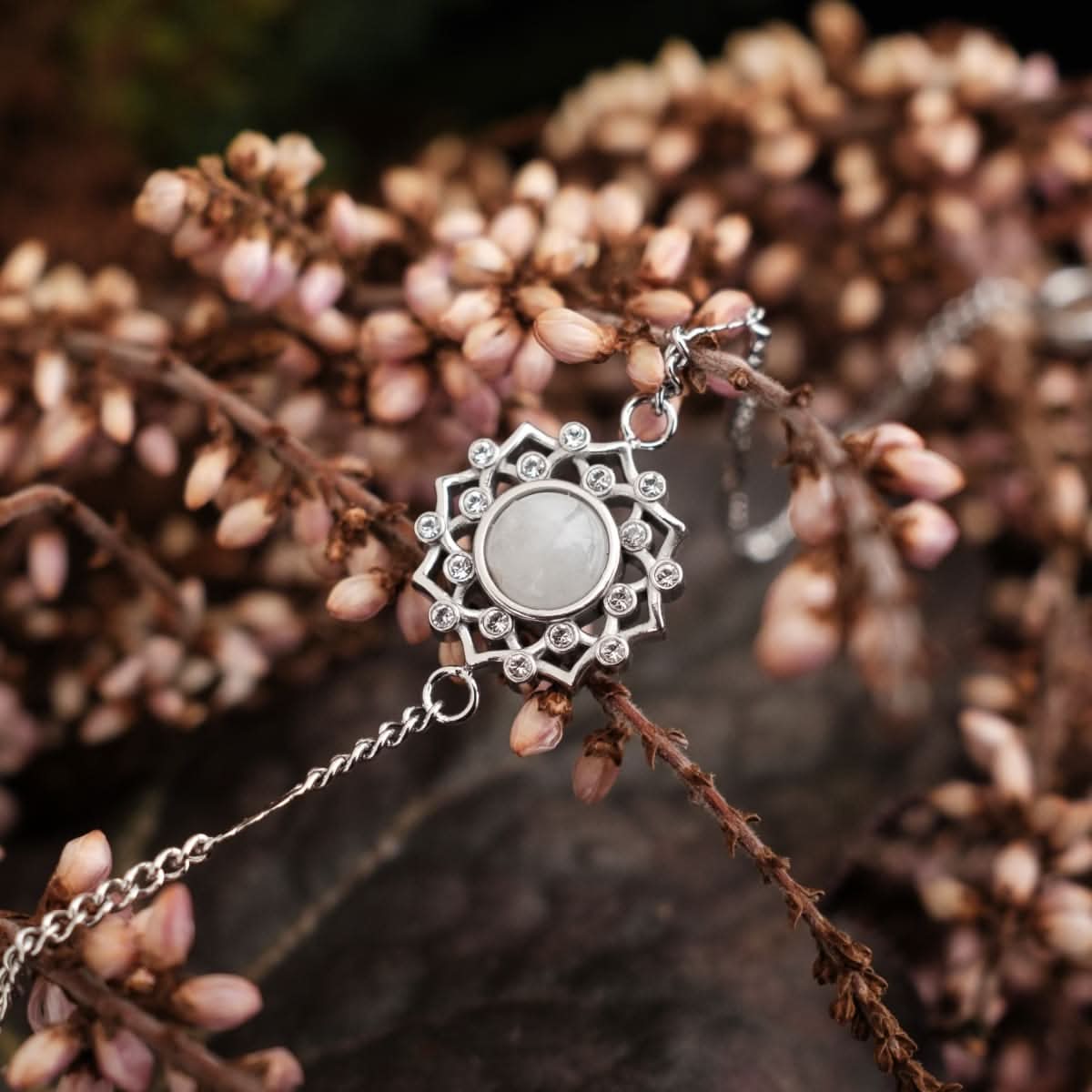 Silbernes Armband mit rundem grauem Stein im Blütenornament und Kette.