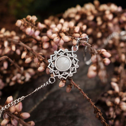 Silbernes Armband mit rundem grauem Stein im Blütenornament und Kette.