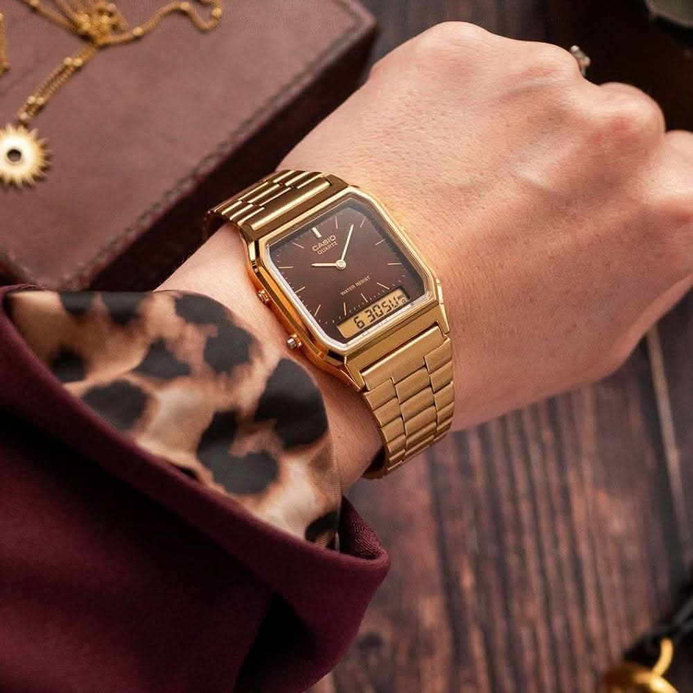 Retro-Uhr am Handgelenk mit goldfarbenem Metallarmband und schwarzem Zifferblatt