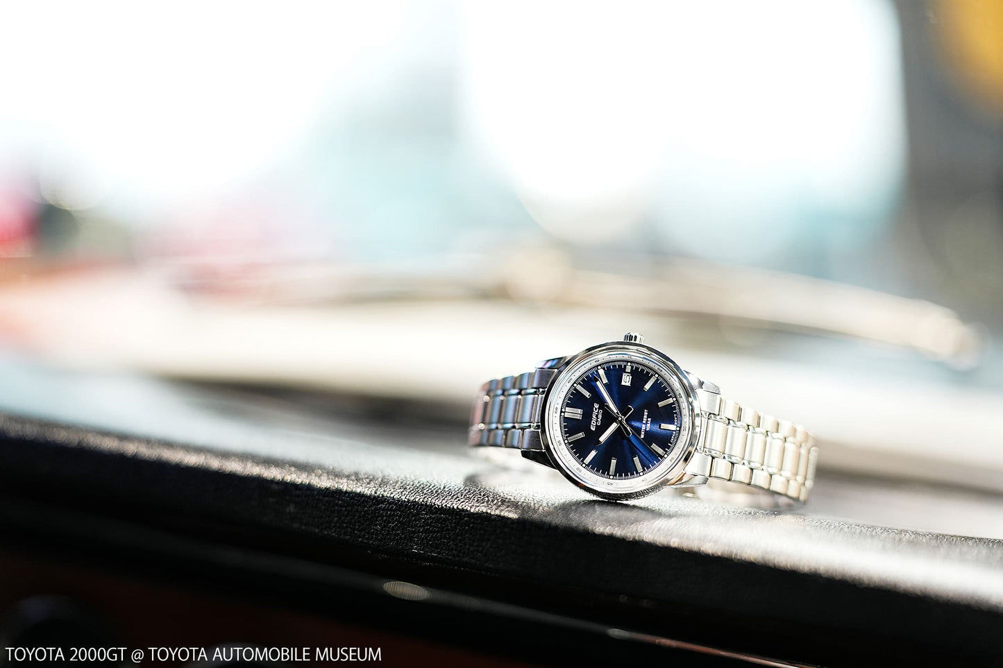 Herrenarmbanduhr seitlich auf dunklem Untergrund, blaues Zifferblatt
