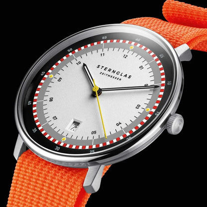 Herrenuhr in Nahansicht: orangefarbenes Armband, weißes Zifferblatt mit gerahmtem Minutenring