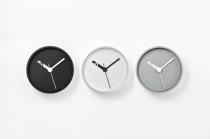 Drei runde Wanduhr-Varianten: schwarze, weiße und graue Zifferblätter mit schwarzen Zeigern.
