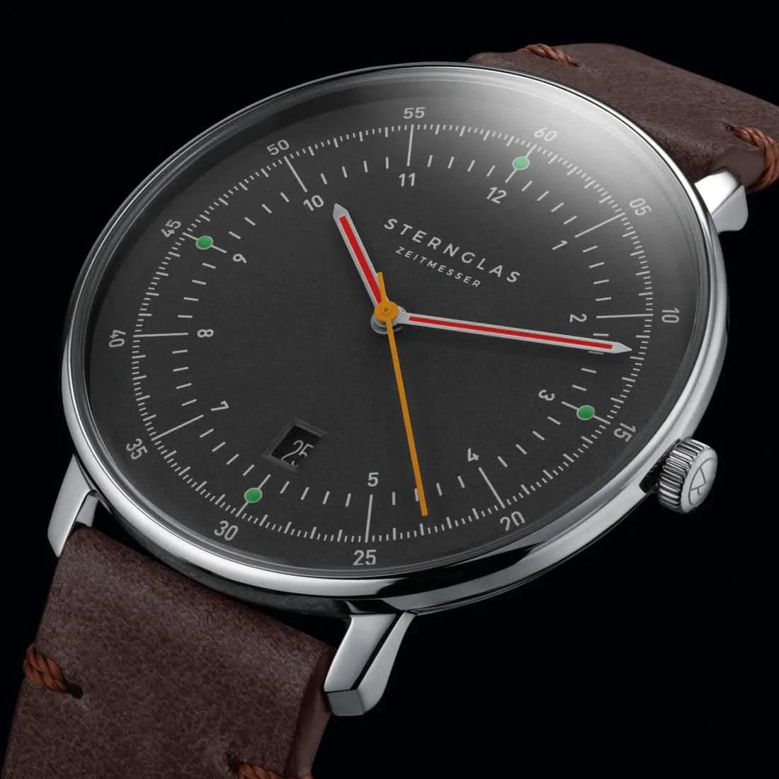 Herrenuhr frontal: braunes Lederarmband, schwarzes Zifferblatt, farbige Zeiger, Datum