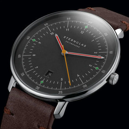 Herrenuhr frontal: braunes Lederarmband, schwarzes Zifferblatt, farbige Zeiger, Datum