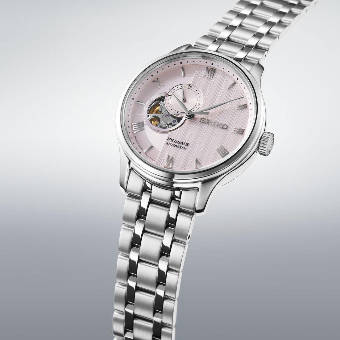 Herrenuhr mit rosafarbenem Zifferblatt und silbernem Metallarmband, seitliche Ansicht