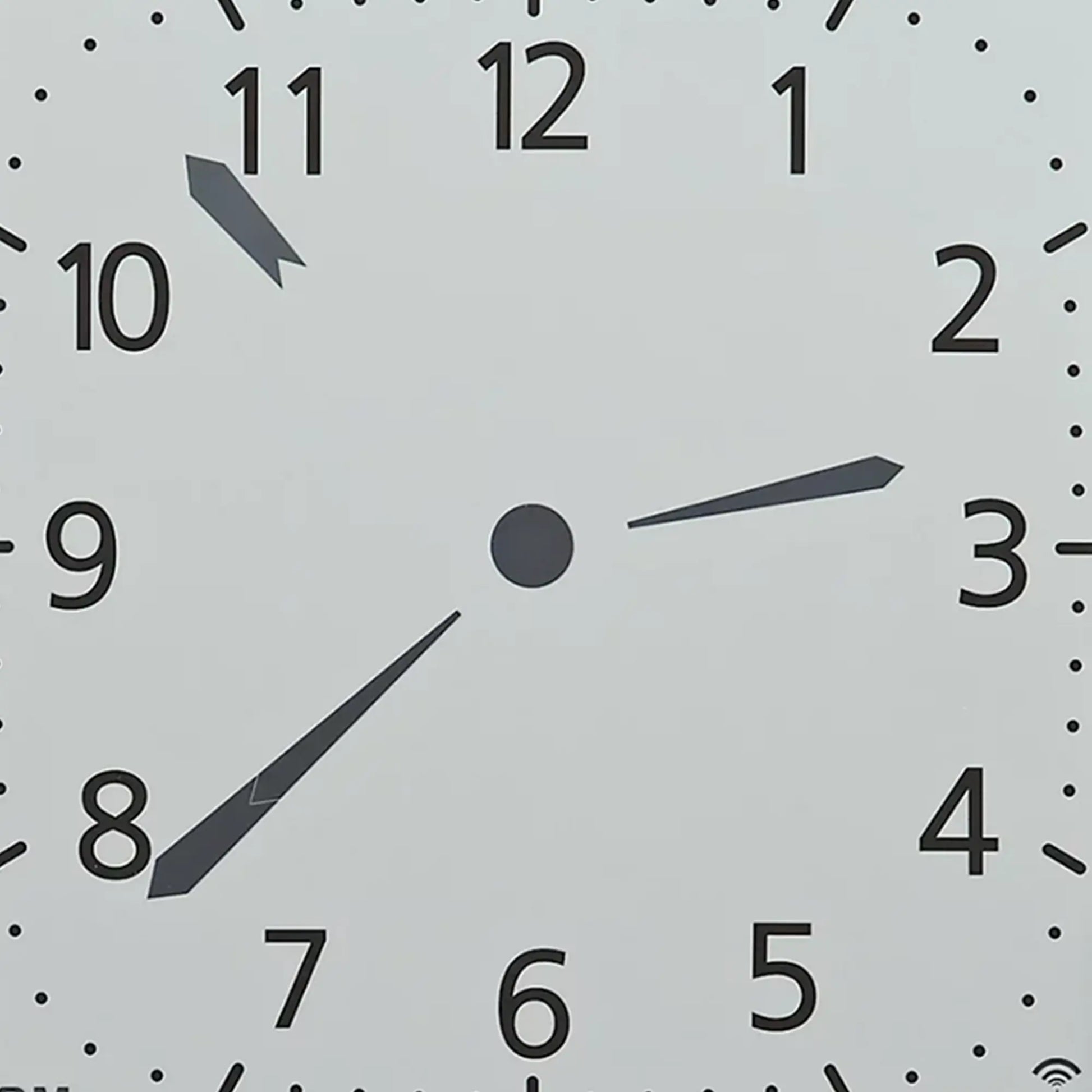 Nahaufnahme des Ziffernblatts einer Wanduhr mit Zeigern und Ziffern 11 bis 4
