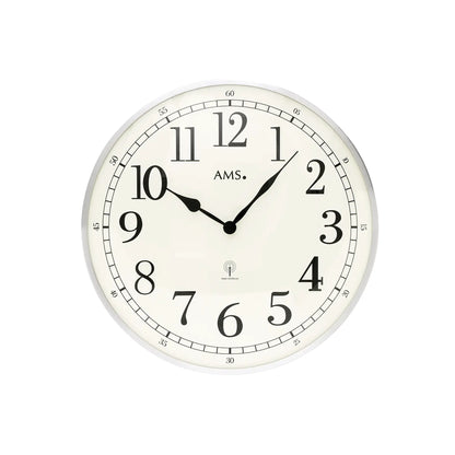 Runde Wanduhr mit weißen Ziffernring, schwarzen Zeigern und AMS-Logo