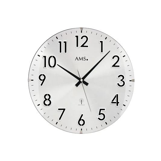 Silberne Wanduhr mit weißem Zifferblatt, schwarzen Zeigern, arabischen Zahlen und AMS-Markierung