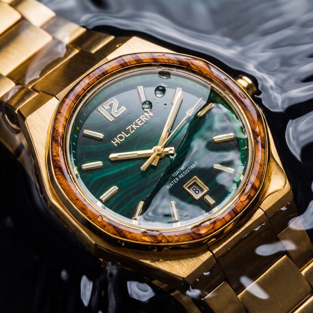 Herren-Armbanduhr mit grünem Malachit-Zifferblatt, goldfarbenes Armband und Holzlünette im Detail