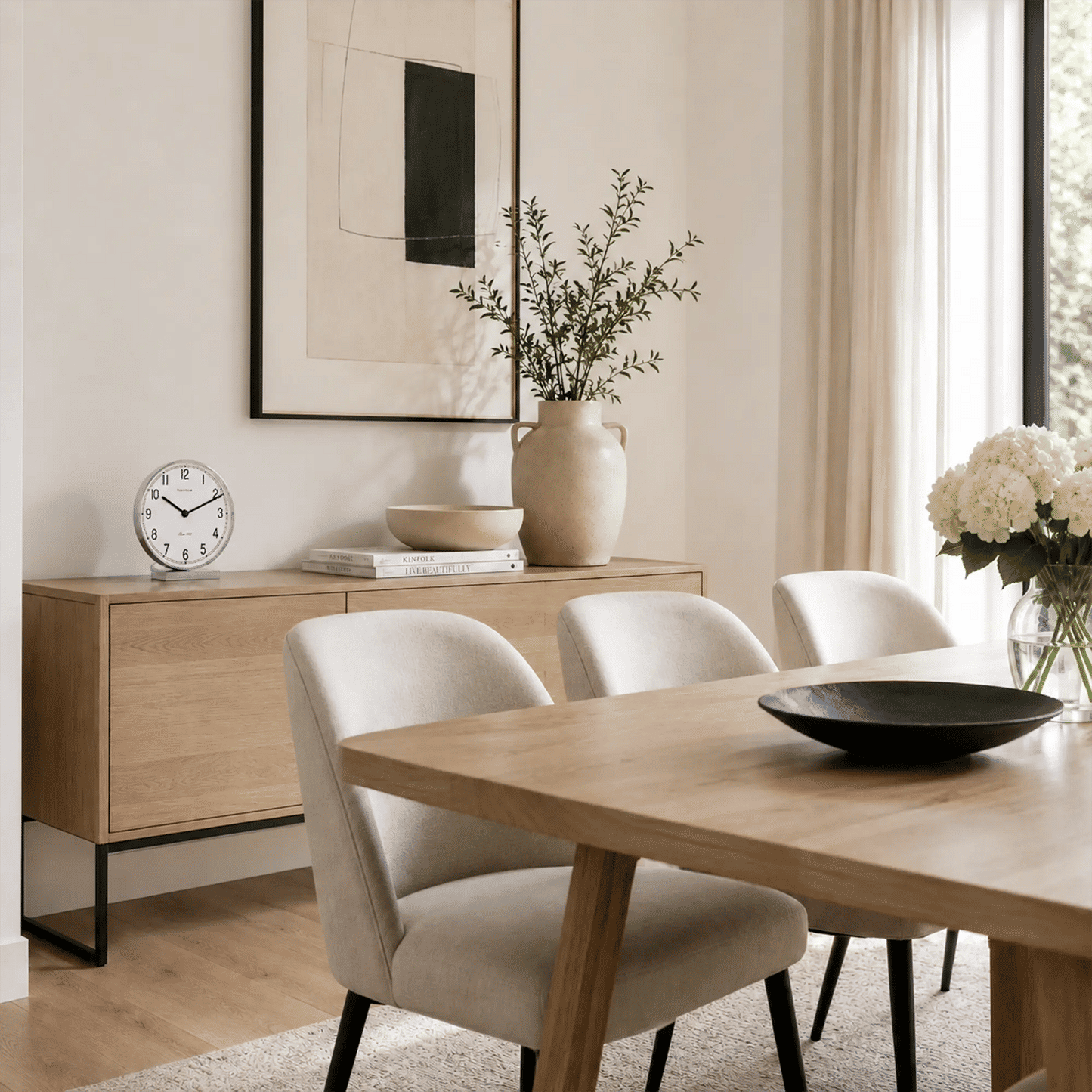 Tischuhr mit weißem Zifferblatt und Chromrahmen auf hellem Sideboard