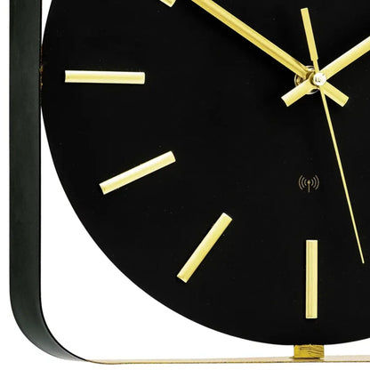 Funkwanduhr mit schwarzem Zifferblatt und goldenen Indexen, goldene Zeiger im Close-up