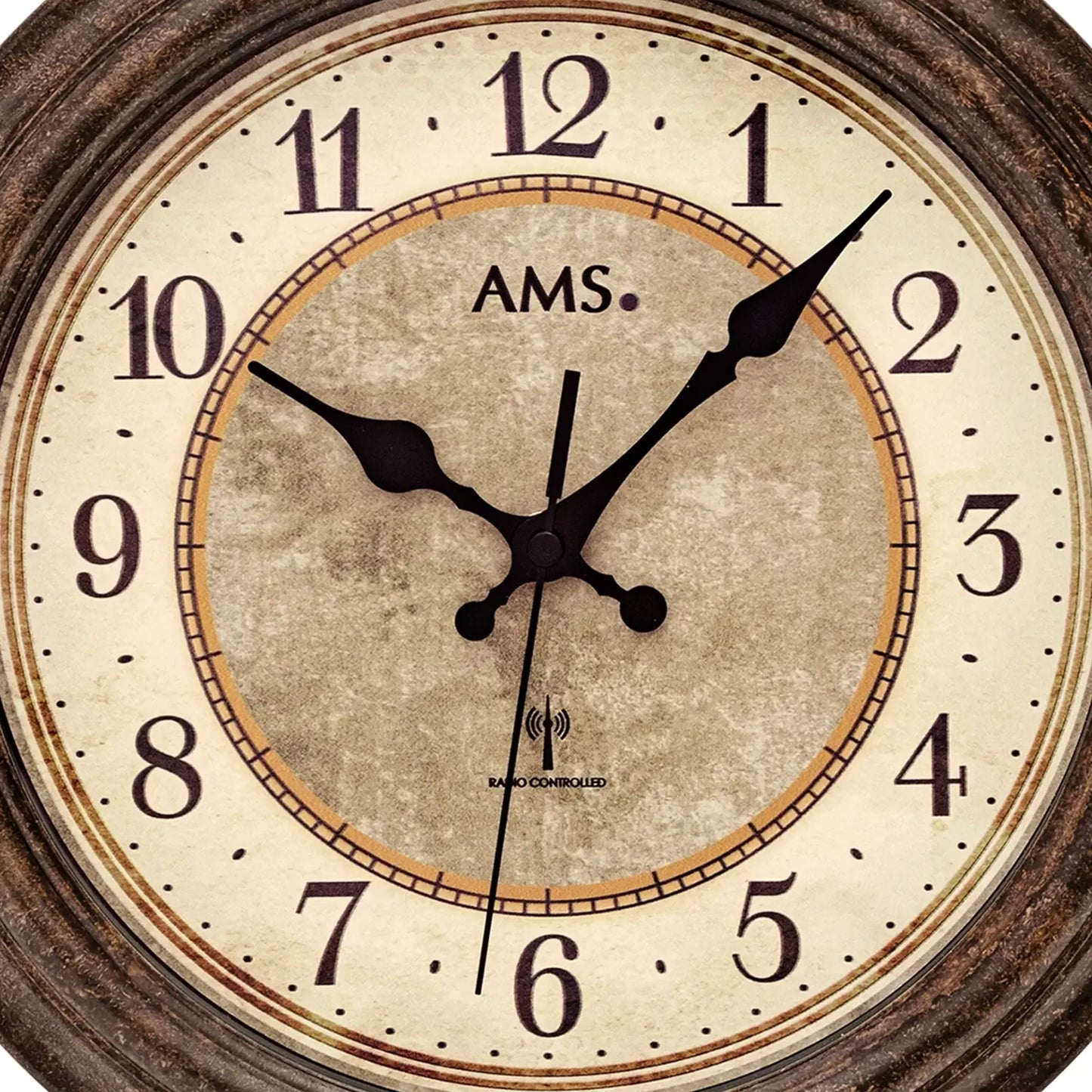 Nahaufnahme: runde AMS Funk-Wanduhr mit antikem Zifferblatt und schwarzen Zeigern