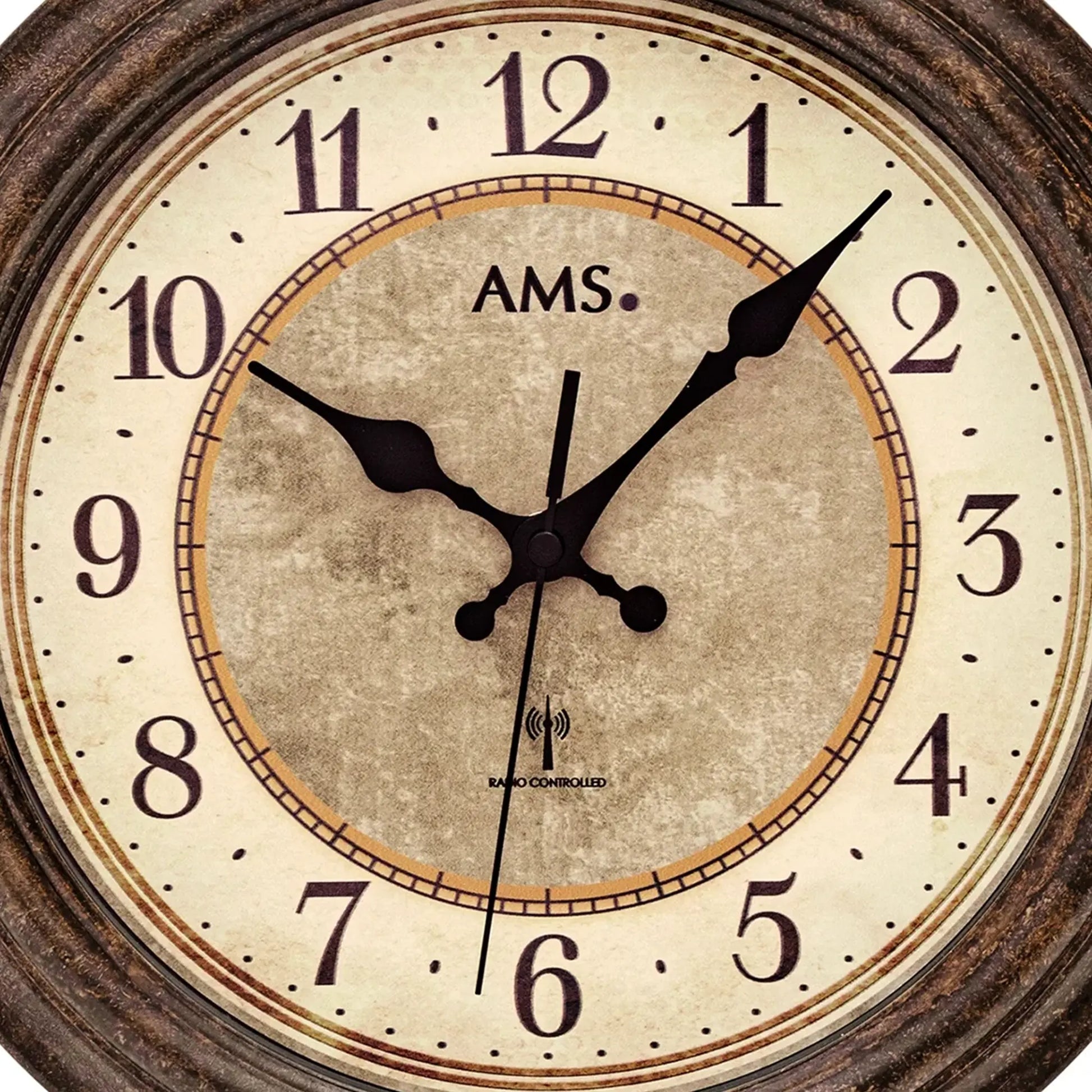 Nahaufnahme: runde AMS Funk-Wanduhr mit antikem Zifferblatt und schwarzen Zeigern