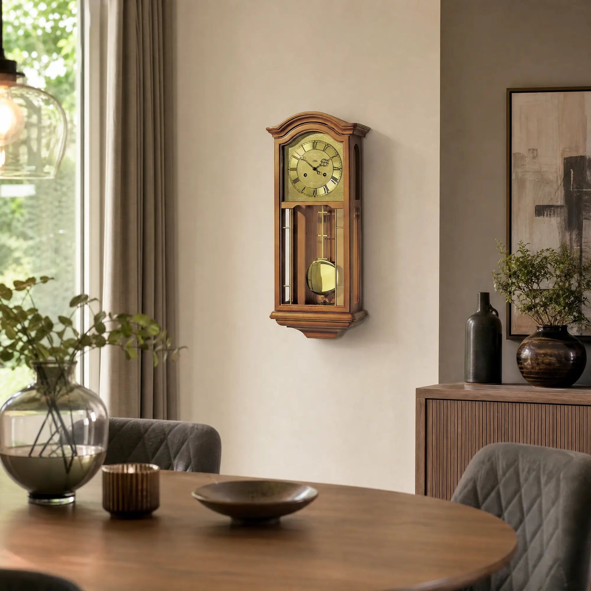 Pendelwanduhr an der Wand, kirschbaumfarbenes Holzgehäuse mit goldener Pendelkugel