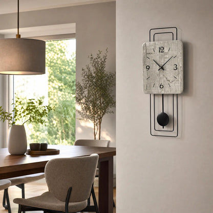 Wanduhr an der Wand mit grauer Betonoptik, schwarzem Pendel und schwarzen Zeigern