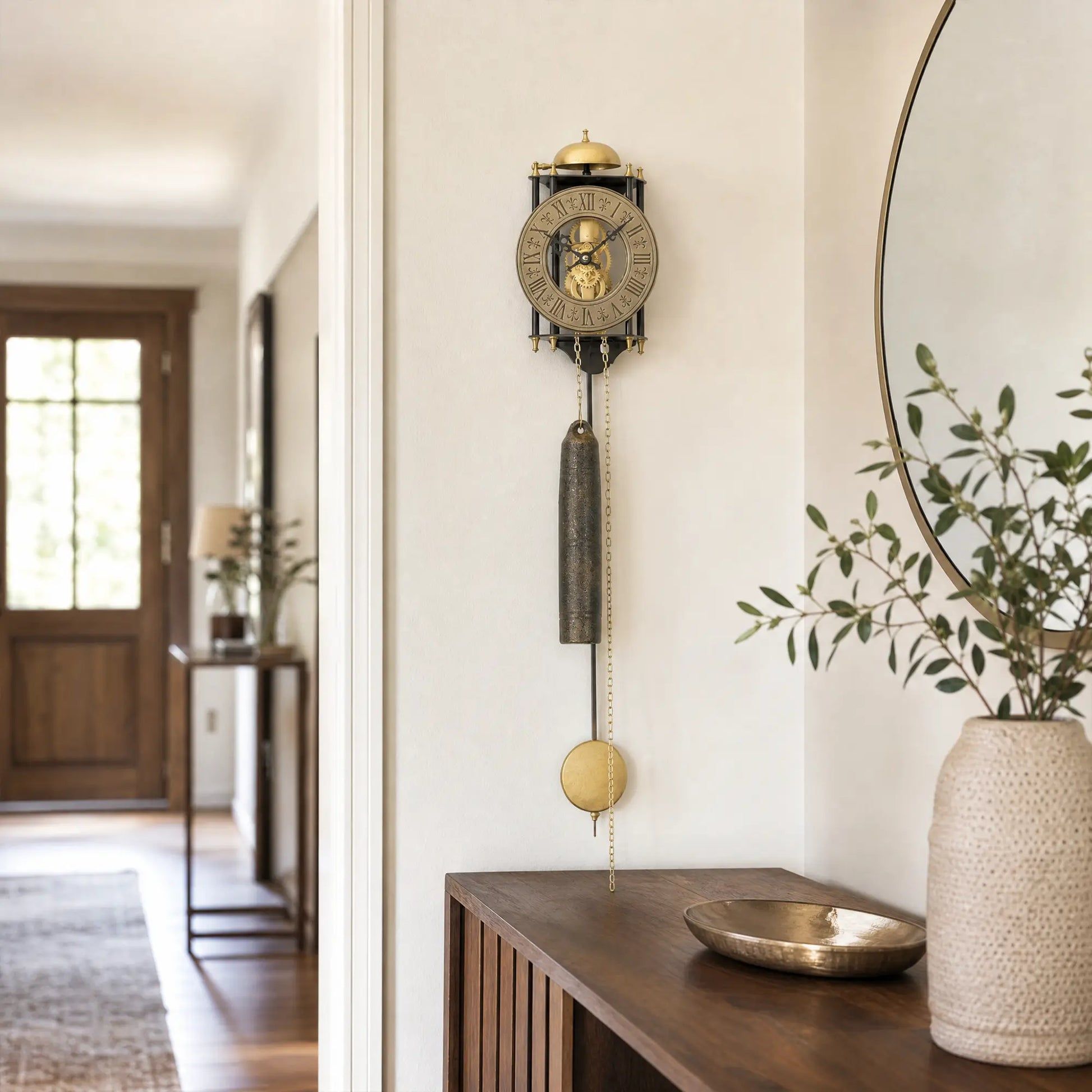 Wanduhr an der Wand mit goldenem Dach, rundem Zifferblatt und Pendelzylinder
