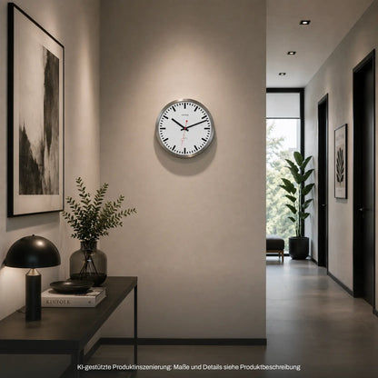 Hermle Wanduhr rund an der Wand: weißes Zifferblatt, silberner Rahmen, rote Zeiger