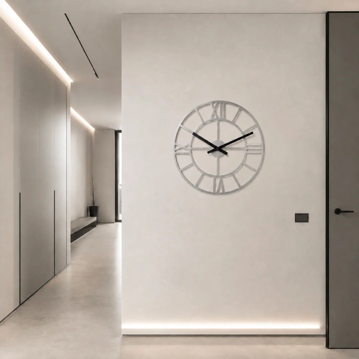 Wanduhr an der Wand mit römischen Ziffern, offenem Rahmen und schwarzen Zeigern
