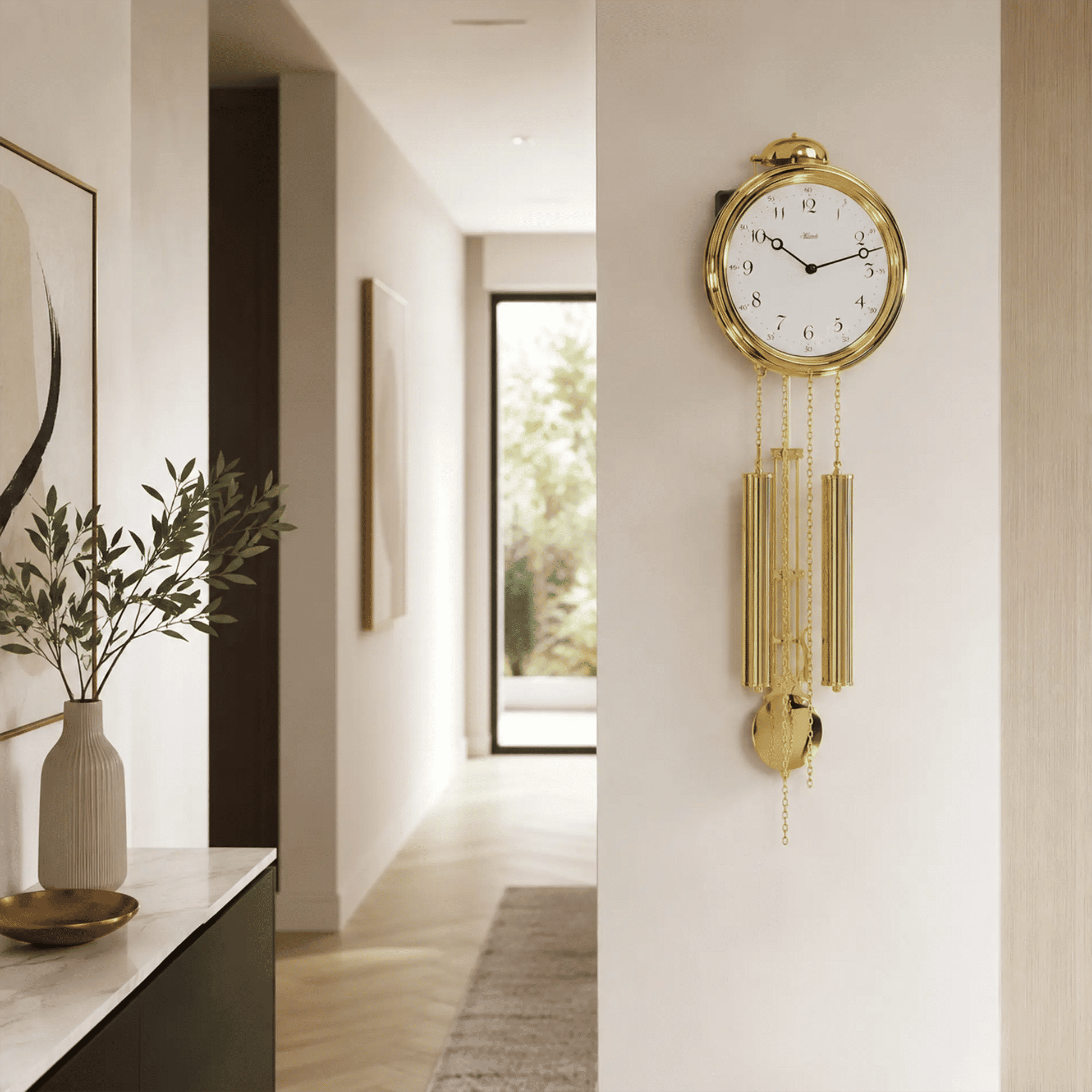 Goldfarbene Wanduhr mit Zierpendeln an der Wand im Flur