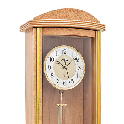 Nahaufnahme der Wanduhr: rundes Zifferblatt, Pendel und goldfarbene Ornamente