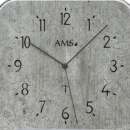 Wanduhr-Zifferblatt mit AMS-Schriftzug, Analogzeiger auf grauem Beton-Look mit Skala