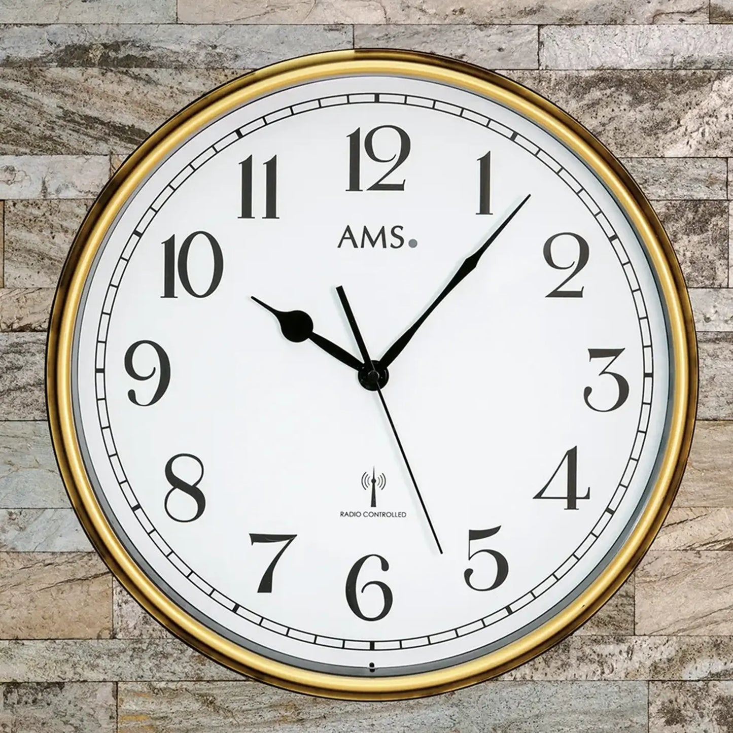 Nahaufnahme Wanduhr: brauner Rahmen, weiße Skala, Funkgesteuert-Text, AMS, Mineralglas