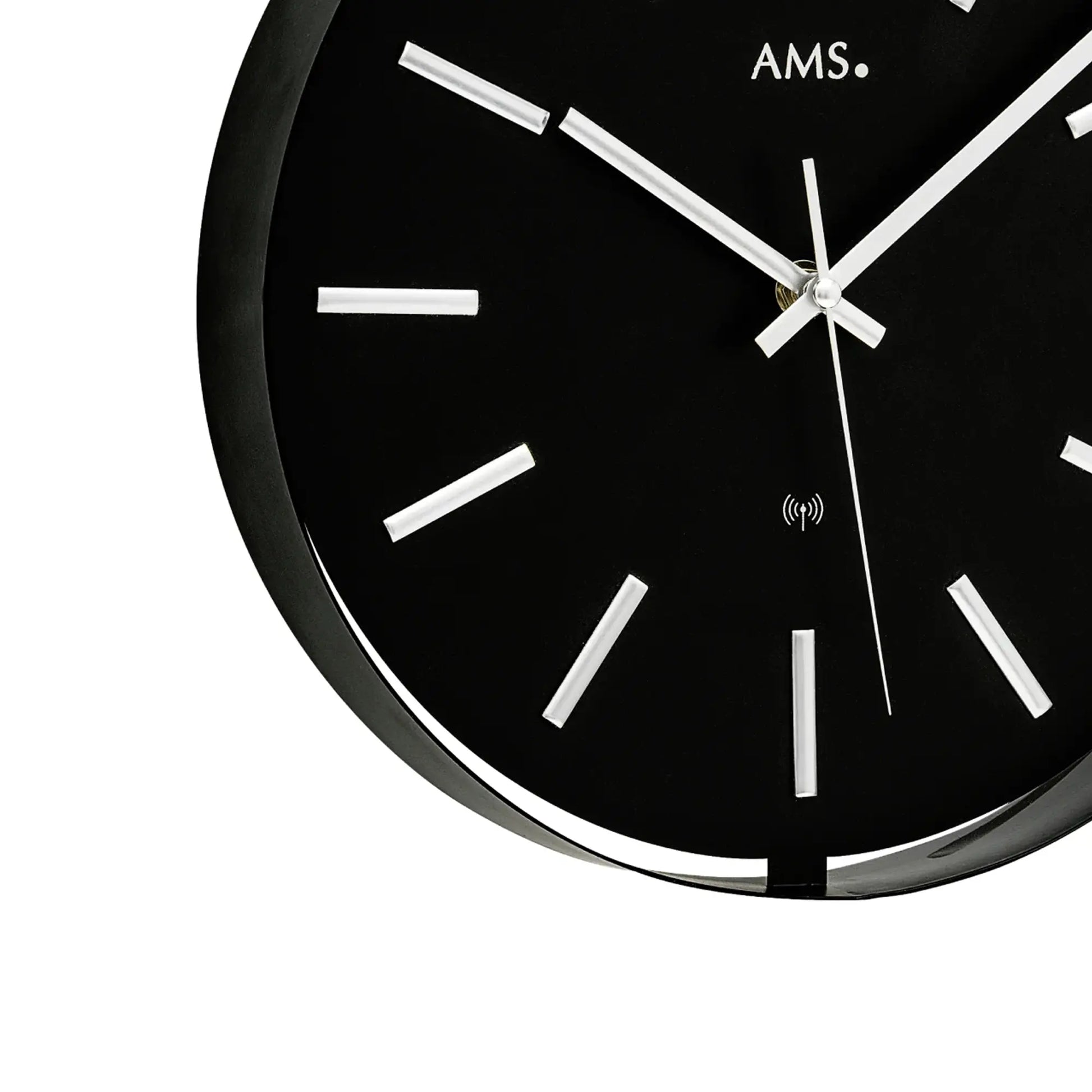Nahansicht AMS Funk-Wanduhr: schwarzes Zifferblatt, silberne Zeiger und Funk-Symbol