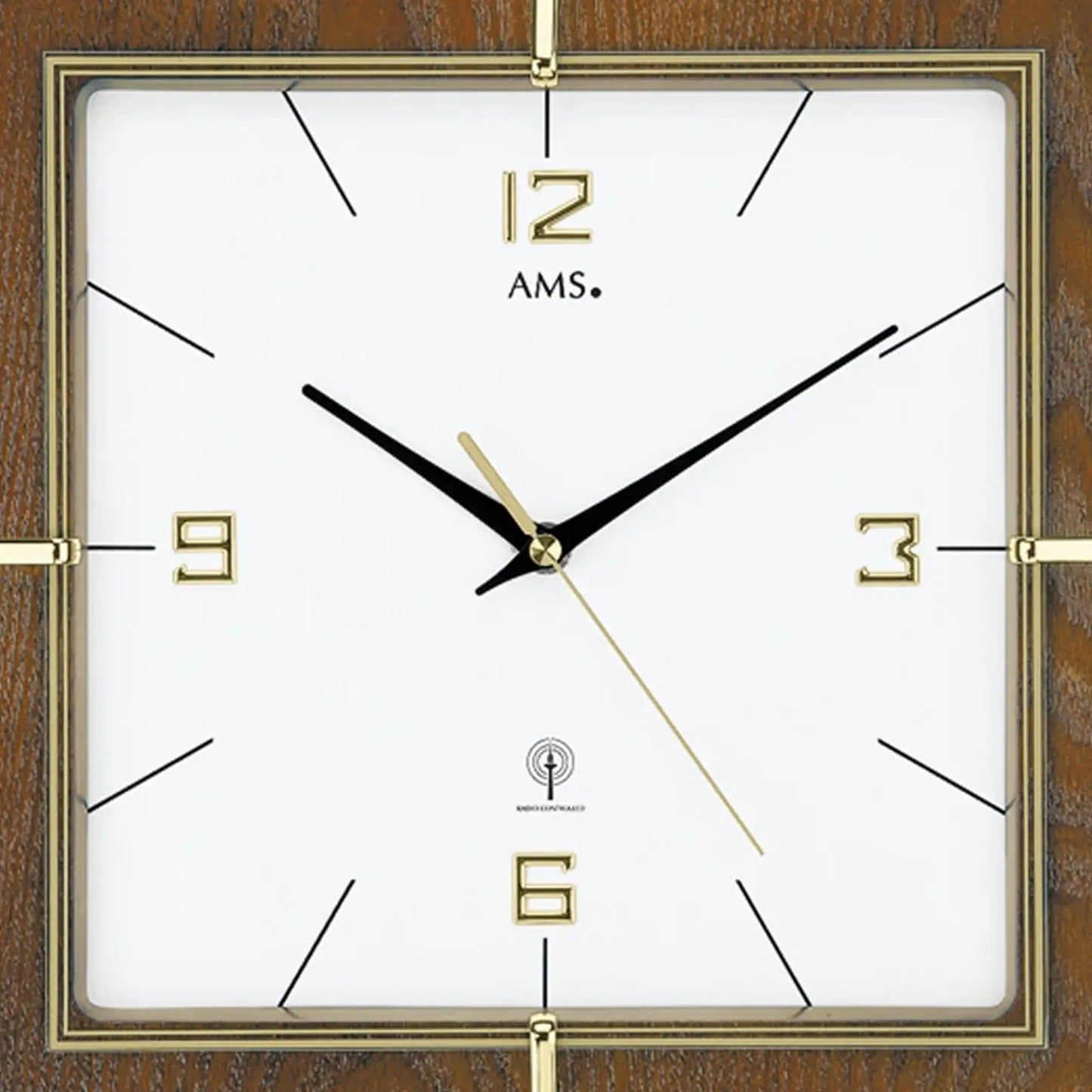 Nahaufnahme: Wanduhr-Zifferblatt mit goldenen Indexen, Mineralglas und schwarzen Zeigern