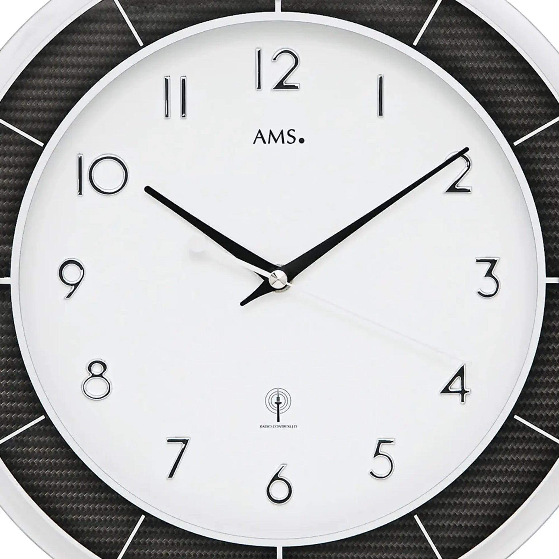 Großansicht Wanduhr: weißes Zifferblatt mit AMS, schwarzen Zeigern und Funksymbol