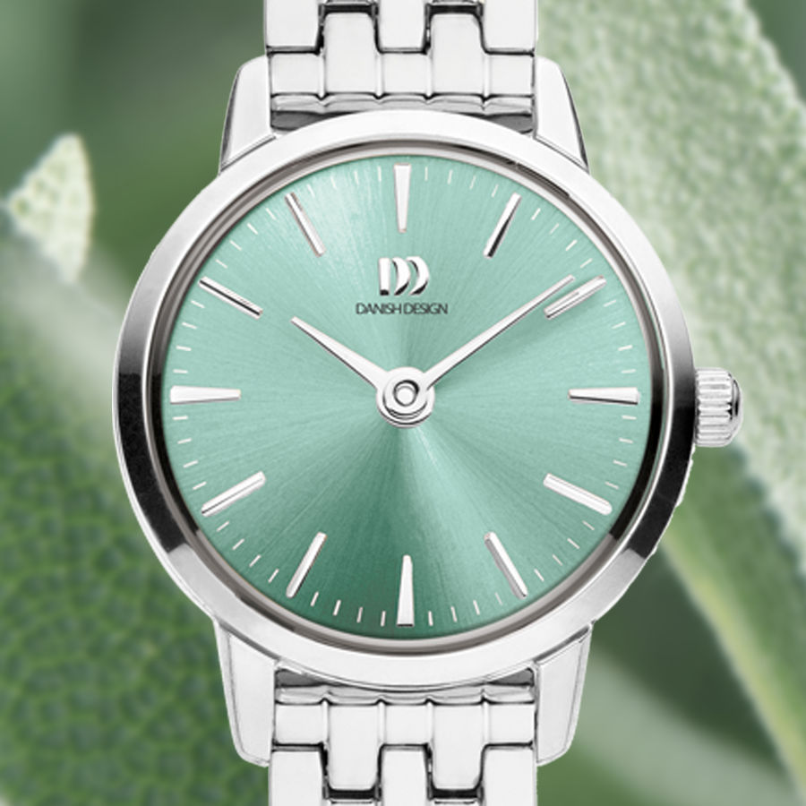 Detale zegarka damskiego: szałwiowa tarcza z indeksami, srebrna luneta
