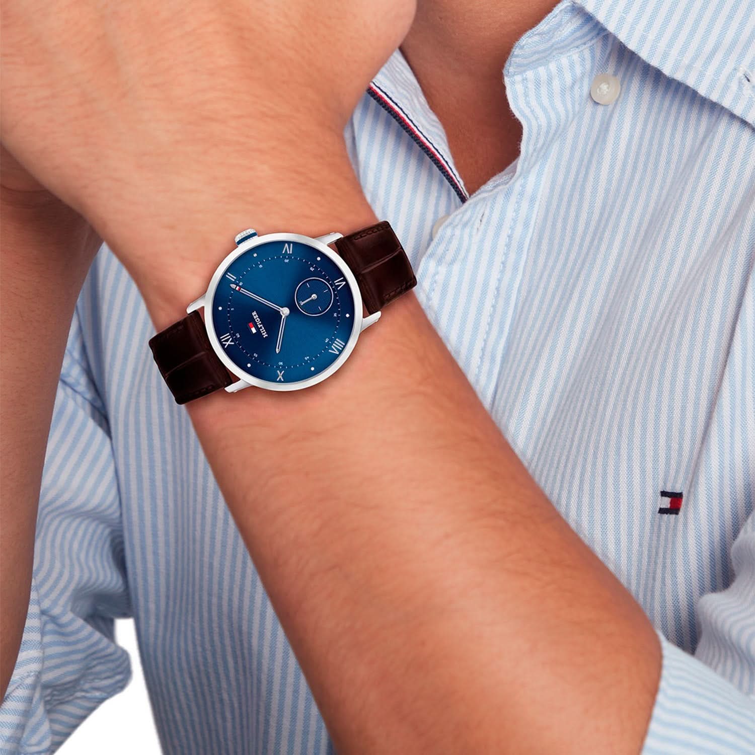 Tommy Hilfiger Herrenuhr mit blauem Zifferblatt und braunem Lederarmband am Handgelenk