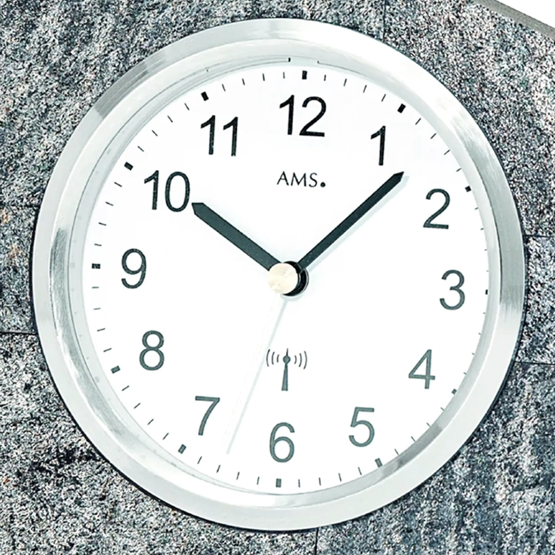 Detail: Tischuhr mit rundem weißen Zifferblatt, AMS und Funkwellen-Symbol