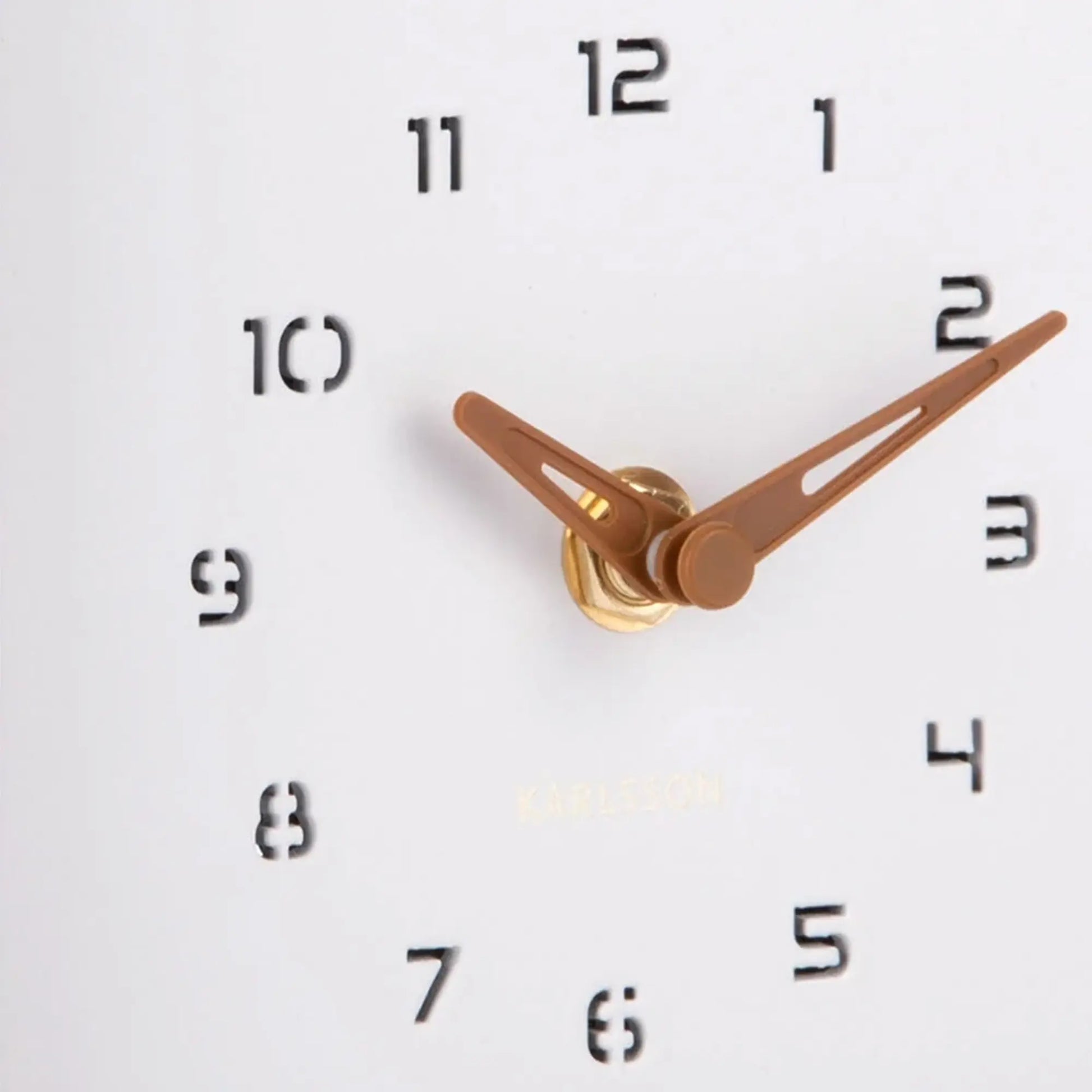 Nahaufnahme der Uhrzeiger und Zahlen auf dem weißen Zifferblatt der Wanduhr